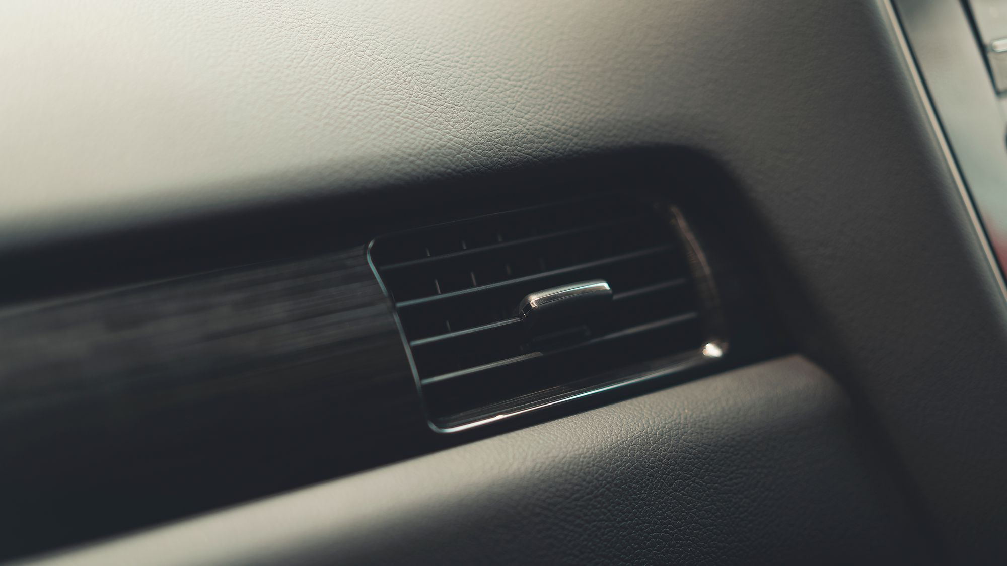 A close view of the air vents in a car dashboard.