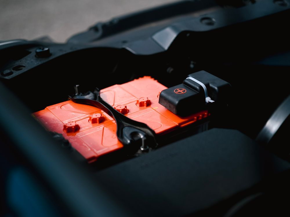 A car battery seen under an open bonnet.