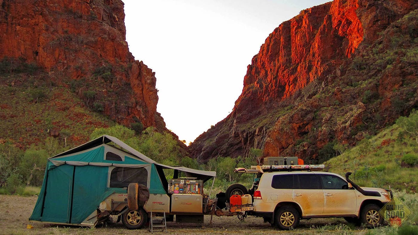 A caravan parked with hills behind it.